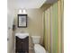 Charming bathroom featuring a striped shower curtain, dark vanity, and modern fixtures, offering practical elegance at 23 Honey Locust, Littleton, CO 80127