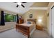 Bedroom with vaulted ceiling, wood furniture, neutral colors, and large window with backyard views at 23 Honey Locust, Littleton, CO 80127