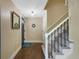 Warm entryway featuring hardwood floors, staircase, and a view of the blue front door at 23 Honey Locust, Littleton, CO 80127