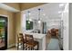 Bright kitchen with white cabinetry, stainless steel appliances, breakfast bar, and open dining area at 23 Honey Locust, Littleton, CO 80127