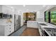 Open kitchen design with stainless steel appliances, white cabinetry, stone countertops, and hardwood floors at 23 Honey Locust, Littleton, CO 80127