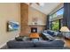 Cozy living room with brick fireplace, high ceilings, comfortable seating, and a large window at 23 Honey Locust, Littleton, CO 80127