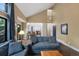 Open-concept living room with high ceilings, hardwood floors, and views into the kitchen at 23 Honey Locust, Littleton, CO 80127