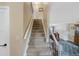 Carpeted staircase with white railings leads to the upper level of the home at 23 Honey Locust, Littleton, CO 80127