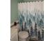Cozy bathroom featuring a toilet with a forest themed shower curtain and decorative walls at 2625 S Xanadu Way # E, Aurora, CO 80014
