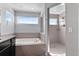 Bright bathroom featuring drop in tub, glass enclosed shower, and a double vanity sink at 23593 E Chenango Pl, Aurora, CO 80016