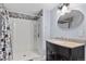 Bathroom featuring a tiled shower with built-in shelves, modern vanity with granite counters, and oval mirror at 23593 E Chenango Pl, Aurora, CO 80016