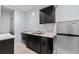 Basement kitchenette with stainless steel refrigerator, dark cabinetry, dual sinks, and marble countertop at 23593 E Chenango Pl, Aurora, CO 80016