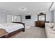 Main bedroom with neutral walls, television, and dark-stained furniture and trim at 23593 E Chenango Pl, Aurora, CO 80016