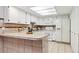 Kitchen featuring tile countertops, tile backsplash, white appliances, and a skylight for natural light at 1390 S Idalia St # 39F, Aurora, CO 80017