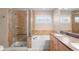 Bathroom featuring a glass shower, soaking tub, double sinks, and tile accents at 3465 Beeler Ct, Denver, CO 80238