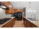 Kitchen with granite counters, stainless appliances, wood cabinets, and hardwood floors at 3465 Beeler Ct, Denver, CO 80238