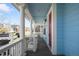 Inviting covered porch with classic white columns and a pop of color from the red front door at 3465 Beeler Ct, Denver, CO 80238