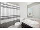Well-maintained bathroom with black and white shower curtain, neutral countertop and sink, plus a large mirror at 14441 E 102Nd Ave, Commerce City, CO 80022