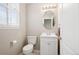Powder room with vanity, framed oval mirror, and natural light from a window at 14441 E 102Nd Ave, Commerce City, CO 80022