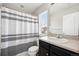 Bathroom with neutral walls, vanity, sink, mirror, shower with white and grey striped shower curtain, and toilet at 14441 E 102Nd Ave, Commerce City, CO 80022