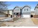 Charming two-story home with a red front door, stone accents, and a two-car garage at 14441 E 102Nd Ave, Commerce City, CO 80022