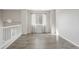 Bright living room featuring wood floors, large windows, and a staircase leading to the lower level at 14441 E 102Nd Ave, Commerce City, CO 80022