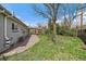 Large backyard featuring a covered patio, mature trees, and ample lawn at 6026 Iris Way, Arvada, CO 80004
