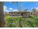 The exterior rear of home, featuring a patio, large yard, and mature trees at 6026 Iris Way, Arvada, CO 80004