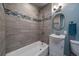 Well-lit bathroom featuring modern sink, mirror, shower, and gray tiled walls at 6026 Iris Way, Arvada, CO 80004