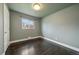 Clean bedroom with dark hardwood floors, a light green wall, and bright natural light at 6026 Iris Way, Arvada, CO 80004