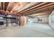 Unfinished basement with concrete walls, exposed ceiling beams, and windows at 7075 Routt St, Arvada, CO 80004