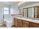 Bathroom featuring a soaking tub and shower, double vanity, and wooden cabinets at 7075 Routt St, Arvada, CO 80004