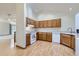 Bright kitchen area with wood cabinets, white appliances, and hardwood floors at 7075 Routt St, Arvada, CO 80004