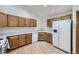 Kitchen featuring wood cabinets, white countertops, and white appliances at 7075 Routt St, Arvada, CO 80004