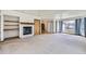 Open-concept living room featuring a fireplace, carpet flooring, and many windows at 7075 Routt St, Arvada, CO 80004