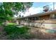 Spacious backyard with mature tree, features a light brick foundation, and access to the home at 6131 Wolff St, Arvada, CO 80003