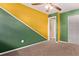Bright bedroom with unique yellow and green wall and adjacent to doorway at 6131 Wolff St, Arvada, CO 80003