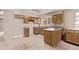 A spacious kitchen featuring an island, wood cabinets, and neutral countertops at 6131 Wolff St, Arvada, CO 80003