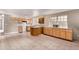 Bright kitchen featuring linoleum floors, wood cabinets, and modern countertops at 6131 Wolff St, Arvada, CO 80003