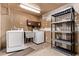 Laundry room with washer, dryer, sink, and shelving for efficient organization at 6131 Wolff St, Arvada, CO 80003
