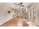 Living room featuring wood flooring, open floorplan, ceiling fan, and sliding glass doors at 6131 Wolff St, Arvada, CO 80003