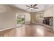 Living room featuring wood flooring, stone fireplace, ceiling fan, and sliding glass doors at 6131 Wolff St, Arvada, CO 80003