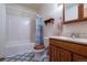 Functional bathroom featuring a tiled shower-tub combo, wood vanity, and neutral color scheme at 15640 Agate Creek Dr, Monument, CO 80132