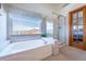 Spa-like bathroom with a large soaking tub, separate glass-enclosed shower, and picturesque window views at 15640 Agate Creek Dr, Monument, CO 80132