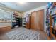 Cozy bedroom with a window and closet, shelves lined with various books, and a decorative rug at 15640 Agate Creek Dr, Monument, CO 80132