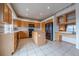Well-lit kitchen boasts an island, wood cabinetry, sleek black appliances, and tiled floor at 15640 Agate Creek Dr, Monument, CO 80132