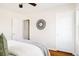 A bedroom with hardwood floors, white walls, and simple decor with a decorative mirror at 2773 S Franklin St, Denver, CO 80210