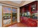 This charming bar area features stunning cabinetry and a view of the deck and sunset at 7883 S Espana Way, Centennial, CO 80016