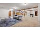 Spacious basement featuring a gray sofa, stairs, wood beams, and a foosball table, great for entertaining at 7883 S Espana Way, Centennial, CO 80016