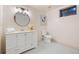 Bright bathroom with a white vanity, round mirror, and patterned tile flooring at 7883 S Espana Way, Centennial, CO 80016
