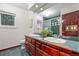 Bathroom with double sinks and green marble countertop, tiling and shower at 7883 S Espana Way, Centennial, CO 80016