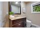A cozy bathroom with a wood vanity, granite countertop, decorative art, and a modern toilet at 7883 S Espana Way, Centennial, CO 80016