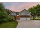 Two-story home with brick and siding, attached three car garage and lush front lawn at 7883 S Espana Way, Centennial, CO 80016