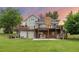 Rear view of the home featuring multiple decks, a brick chimney, and a lush green lawn at 7883 S Espana Way, Centennial, CO 80016